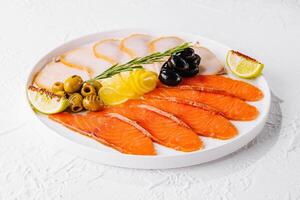 salmone, bianca pesce e olive su piatto foto