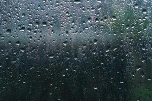 piovoso giorni pioggia gocce su il finestra superficie. sfondo e trama di bagnato finestra con piovoso gocce foto