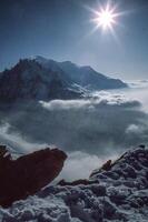un' persona in piedi su un' montagna superiore con un' neve coperto paesaggio foto