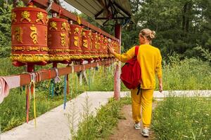 persona pellegrino donna toccante svolta Filatura buddista preghiera ruota a buddista monastero. preghiera ruote nel buddista stupa tempio. buddismo religione concetto foto