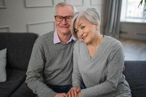 anziano adulto maturo coppia abbracciare a casa. medio età vecchio marito e moglie Abbracciare una persona con tenerezza amore godendo dolce bonding benessere. nonna nonno insieme. famiglia momento amore e cura foto