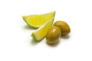 due olive e un pezzo di limone e lime isolato su bianco