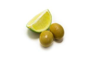 due olive e un pezzo di limone e lime isolato su bianco