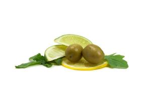 due olive, un pezzo di limone e foglie di rucola isolate su bianco foto