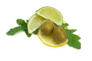 due olive, un pezzo di limone e foglie di rucola isolate su bianco foto