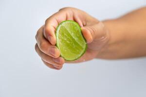 femmina mano spremitura metà fresco Limone isolato su bianca sfondo. spremitura fresco Limone vicino su. alto vitamina c naturale foto