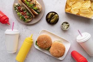 vista dall'alto di fast food, hotdog, patatine, hamburger e bevande foto