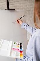 artista femminile che dipinge su tela in studio foto