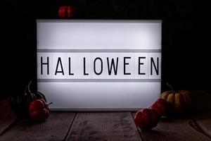 scatola luminosa di halloween nella stanza buia con zucche sul pavimento di legno foto