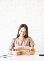 studentessa adolescente sorridente felice che tiene una pila di libri foto