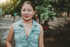 ritratto di latino americano ragazza viso guardare e sorridente a il telecamera. ritratto di giovane nicaraguense donna sorridente a telecamera. ritratto di attraente latino ragazza sorridente all'aperto foto