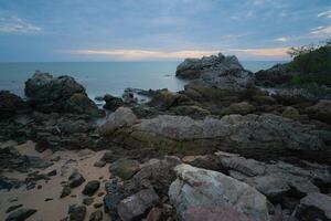 Alba o tramonto a mare, calma onde e roccioso costa. foto