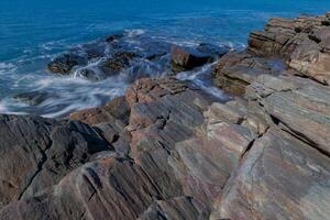 rocce e mare con onde, lungo otturatore foto