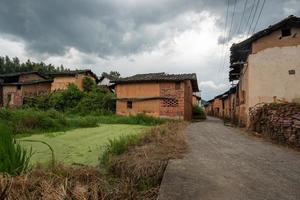 una strada che conduce lontano in campagna, con case e boschi o campi verdi foto