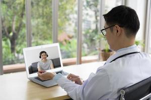 giovane medico asiatico che mostra come palpare il polso radiale al paziente tramite videoconferenza. telemedicina e concetto medico online foto