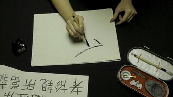 donna di mano scrittura Cinese calligrafia. femmina mano Tenere un' scrittura spazzola Cinese personaggi foto