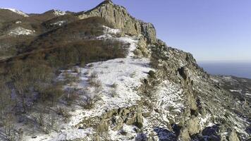 mozzafiato paesaggio di ripido pietroso versante di montanaro fusione neve nel primavera soleggiato sera. azione filmato. bellissimo naturale Visualizza di montagna con alto, pericoloso roccioso cime. foto