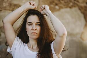 ai generato donna con fluente capelli con sollevato cazzotto, ragazza energia foto