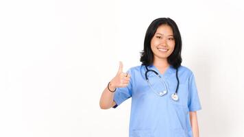 giovane asiatico femmina medico mostrando pollici su isolato su bianca sfondo foto