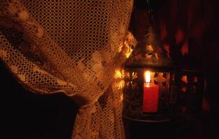 un' candela è illuminato nel un' buio camera foto