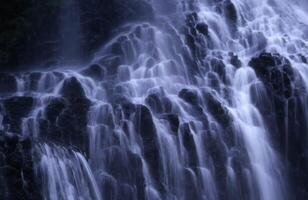 un' cascata è mostrato nel il buio foto