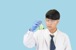 asiatico uomo alunno scienziato nel reagente miscelazione laboratorio nel un' scienza ricerca laboratorio con test tubi di vario taglie. su il pavimento nel laboratorio chimica laboratorio blu sfondo. foto