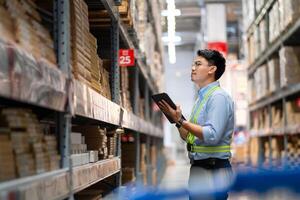 magazzino lavoratore nel sicurezza uniforme con tavoletta computer guardare a merce nel grande magazzino la logistica e esportare attività commerciale la logistica distribuzione centro. foto