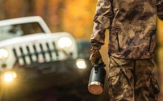 un' uomo con un' thermos andando per il suo awd veicolo mentre su un' via strada viaggio foto