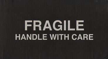 segno fragile su scatola di cartone ondulato nero foto