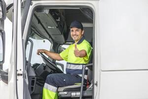 allegro maschio autista mostrando pollice su gesto mentre seduta nel camion Immagine foto
