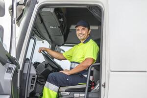 sorridente maschio autista seduta nel camion e guardare a telecamera foto