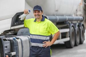 sorridente camion autista in piedi di veicolo al di sopra di sfocato sfondo foto