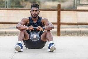 muscolare africano americano uomo esercizio con kettlebell nel gli sport terra foto