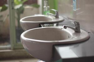 Due lavabo per Asia pubblico gabinetto, Due moderno ceramica lavabi, ceramica Lavello con cromo miscelatore nel contemporaneo bagno. foto