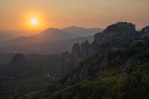 bellissima vista delle montagne di meteora e dei monasteri al tramonto foto