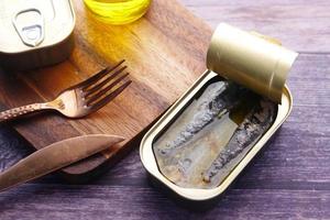 aprire la lattina di sardine su sfondo di piastrelle bianche. foto
