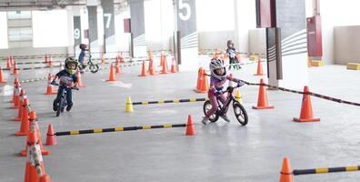 depok-indonesia, 29 07 2023 - indonesiano bambini a partire dal 2-5 anni vecchio gare su equilibrio bicicletta nel un' parcheggio la zona, sportività formazione foto