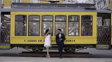 turista strada. Lisbona- Portogallo, 06.12.2022. azione. giovane persone nel estate abiti posa nel davanti di un' statua di un' tram macchina. uso solo per editoriale. foto