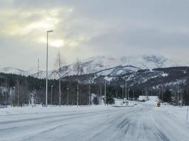 guidando attraverso la strada bianca innevata e il paesaggio in norvegia. foto