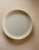 ai generato bianca ceramica piatto modello, vuoto modello di piatto su tavolo foto