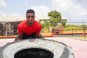 atletico uomo sollevamento un' grande Palestra pneumatico nel Palestra foto