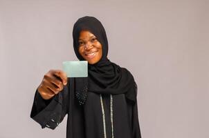 bellissimo musulmano giovane donna con attività commerciale carta nel mano foto
