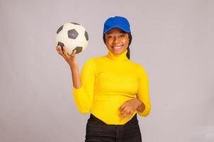 foto di affascinante giovane signora hold calcio indossare giallo camicia isolato al di sopra di bianca sfondo
