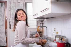 donna ha divertimento mentre preparazione biscotti a casa. foto