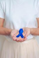 marzo colorettale cancro consapevolezza mese, medico con buio blu nastro per supporto persone vivente e malattia. assistenza sanitaria, speranza e mondo cancro giorno concetto foto
