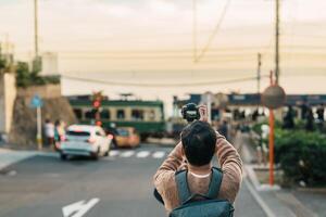 uomo turista visitare nel Kamakura, Kanagawa, Giappone. contento viaggiatore giro turistico kamakurakokomae treno stazione. punto di riferimento e popolare per turisti attrazione vicino tokyo. viaggio e vacanza concetto foto