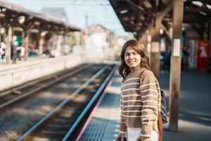 donna turista in attesa treno e visitare nel Kamakura, Kanagawa, Giappone. contento viaggiatore giro turistico kamakura treno stazione. punto di riferimento e popolare per turisti attrazione vicino tokyo. viaggio e vacanza foto