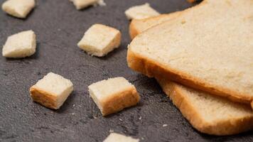 affettato pane isolato su grigio sfondo. pane tagliare in piccolo piazze foto