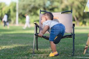 poco ragazzo ragazzo giocando all'aperto nel il giardino, bambino ragazzo nel il parco foto