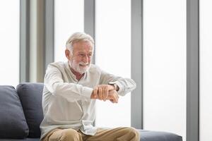 anziano uomo sofferenza a partire dal morbo di Parkinson sindrome, uomo Tenere polso sensazione dolore, anziano uomo Tenere il suo mano mentre sofferenza a partire dal osteoporosi foto